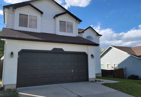 home exterior with white siding and black accents on garage door and trim