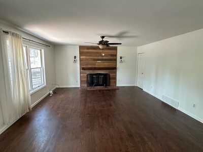 empty main room in house with hardwood floors and fireplace