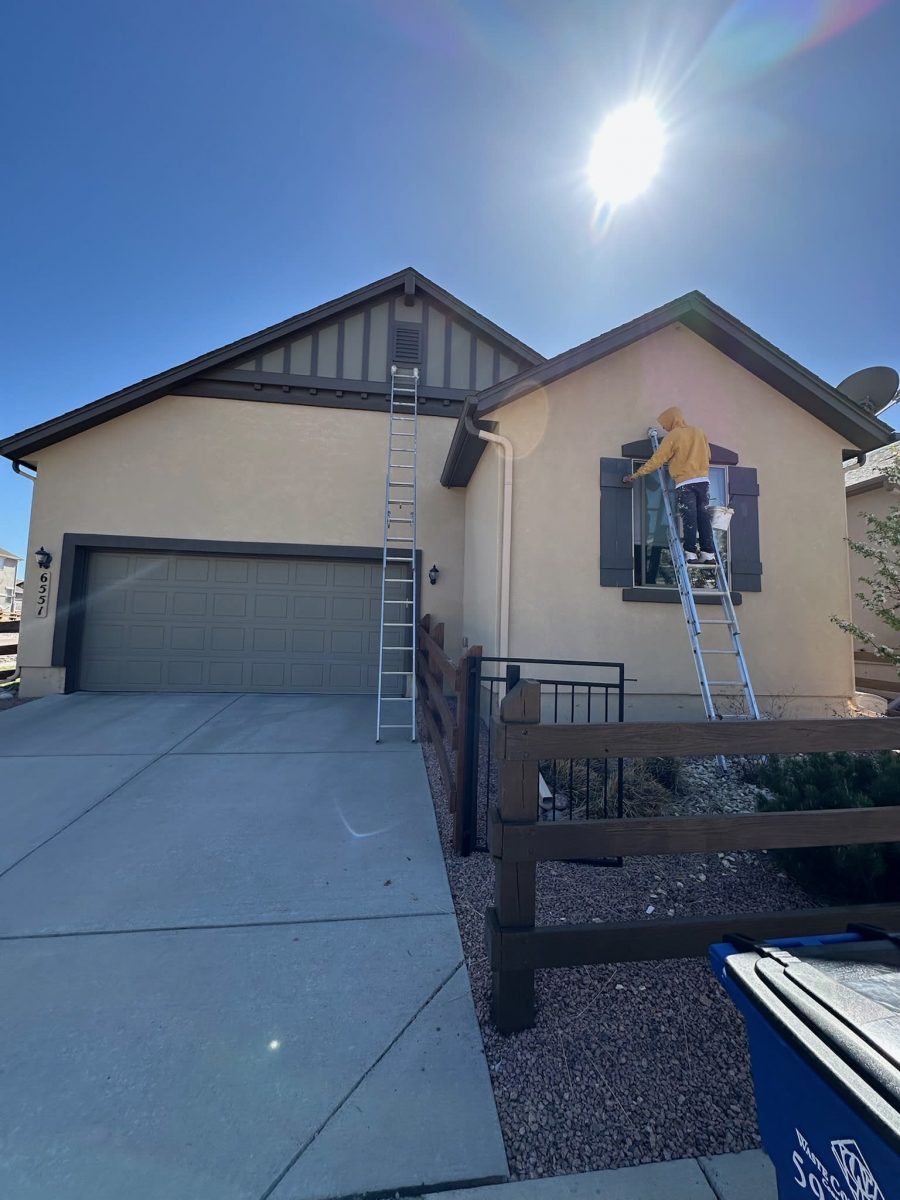 painter on ladder painting a stucco house Preview Image 1