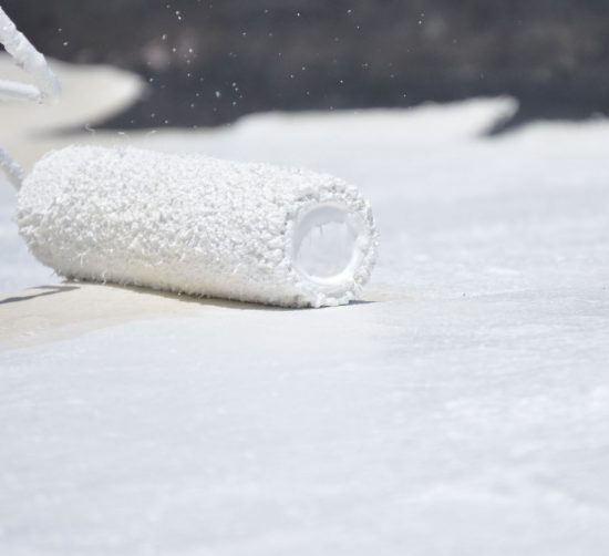 paint roller applying commercial grade roof coating paint