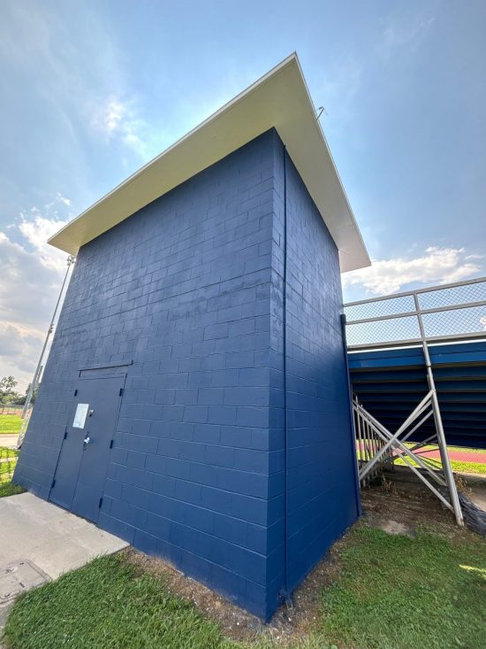 blue painted school athletic building with damaged paint
