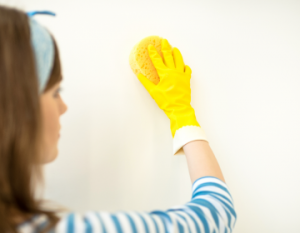 woman cleaning painted walls