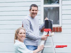 couple painting home exterior 