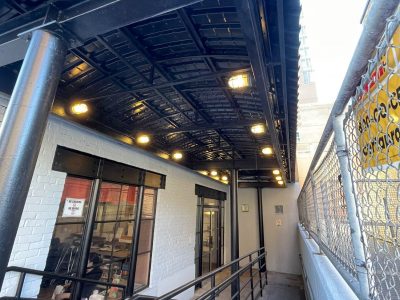 sidewalk view of commercial space ramp to entrance after painting