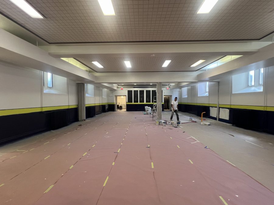 painter walking through school gym with floors covered for repainting project Preview Image 2