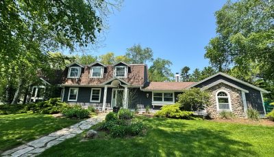 Front exterior of blue painted house and front yard