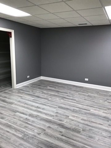 Bedroom with newly painted gray walls and gray flooring