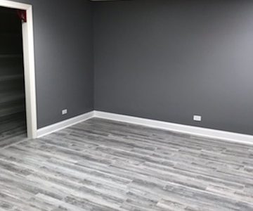 Bedroom with newly painted gray walls and gray flooring