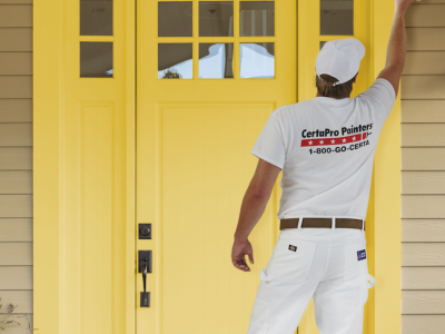 Exterior Painter painting front door yellow.