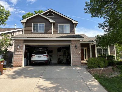 painted front of house with open garage door and driveway