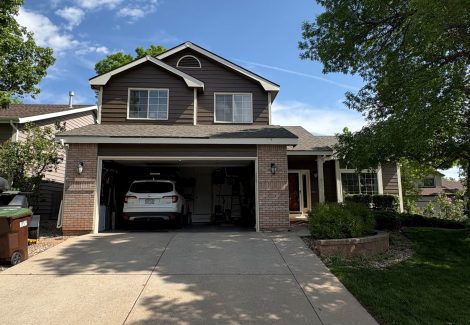 painted front of house with open garage door and driveway