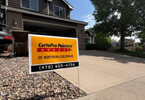 painted front of house with open garage door and driveway