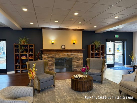 lounge area with stone fireplace and blue painted drywall