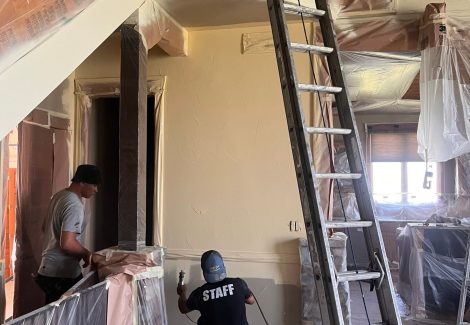 ladder and painters working on interior of house