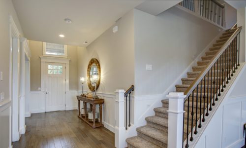 Foyer with white walls and carpeted staircase