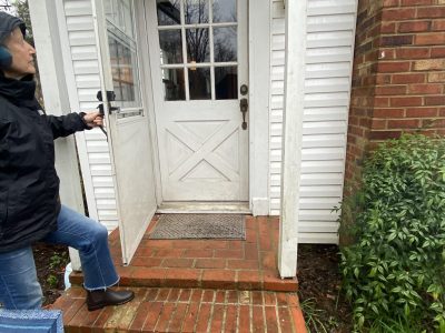 home with white siding door damage before