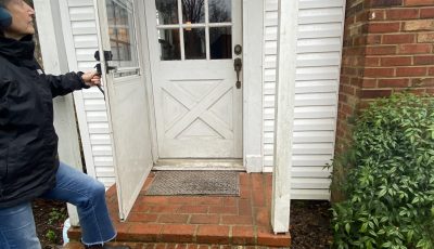 home with white siding door damage before