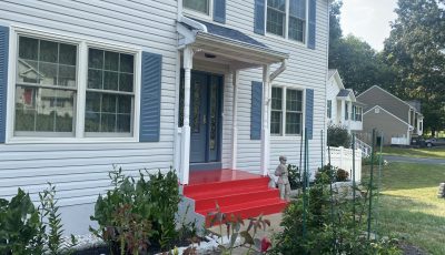 home with white siding and brick foundation and red steps