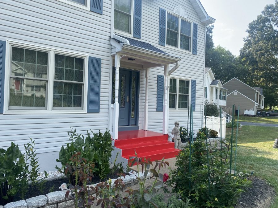 home with white siding and brick foundation and red steps