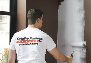 CertaPro worker painting wall