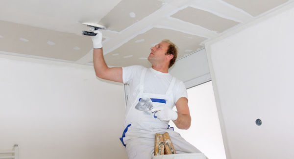 Worker painting ceiling.