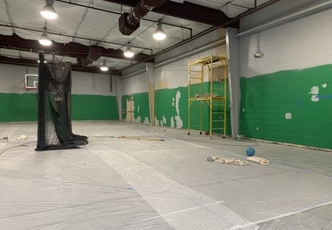 yellow and green painted walls of the Collierville gym interior being primed for repainting