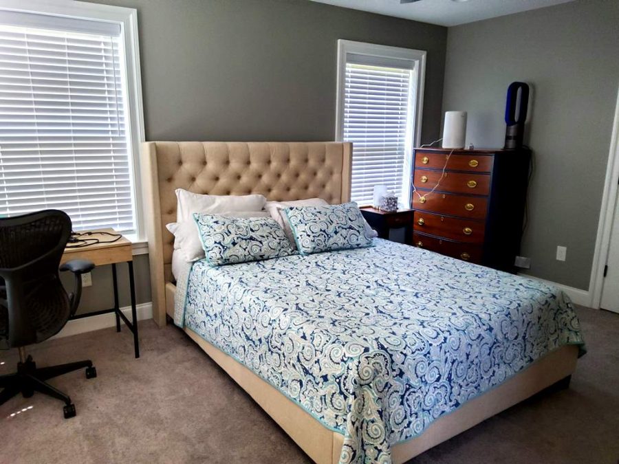 bedroom with grey walls and a tan headboard