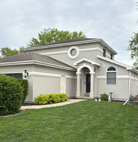 painted stucco house with white trim accents