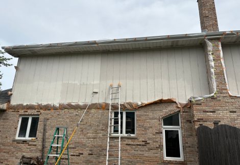 ladder and paint equipment leaning against house