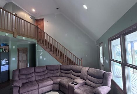 living room with couch and staircase to loft