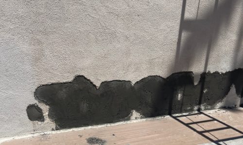 An area of stucco that is awaiting patching.