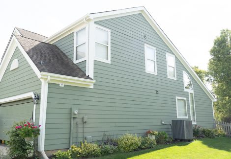 side of home painted green with white trim