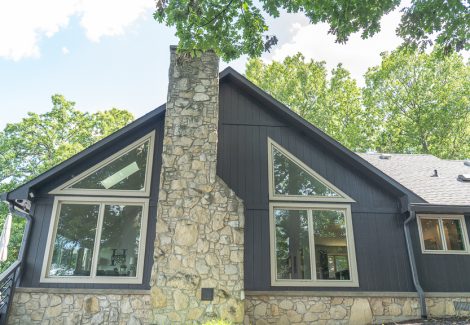 side of home with painted wood siding and masonry chimney