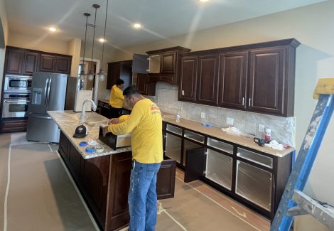 painters in home kitchen prepping for cabinet painting