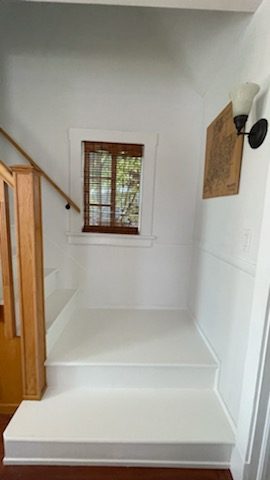 White staircase landing with natural wood railings. Preview Image 2