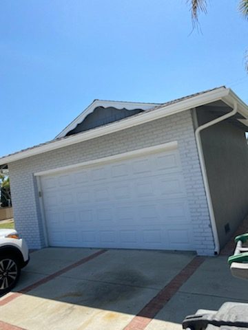 Brick wall painted light gray surrounding a white garage door. Preview Image 2