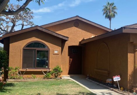 Entrance to stucco home painted a dark tan with brown trim.