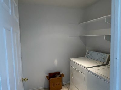 A laundry room painted a very light gray.