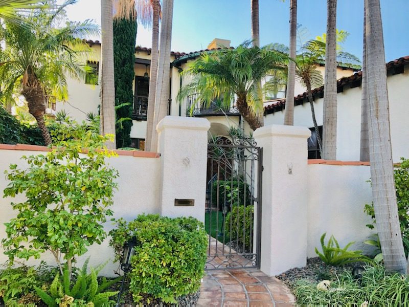 a Tile capped stucco privacy wall around a house with a wrought iron gate. Preview Image 3