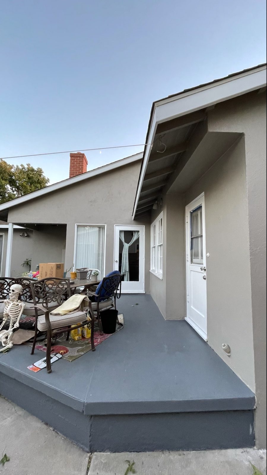 taupe colored stucco house with a gray concrete deck. Preview Image 1