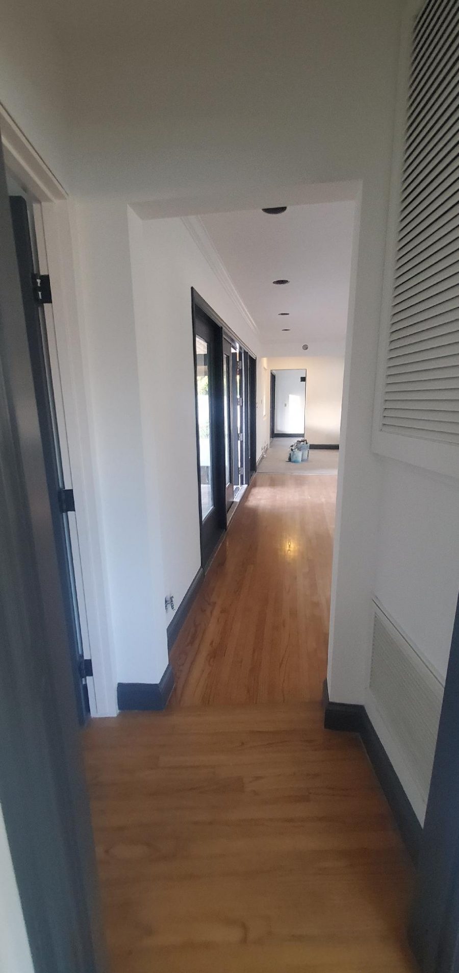 Hallway of home painted white with dark gray trim. Preview Image 10