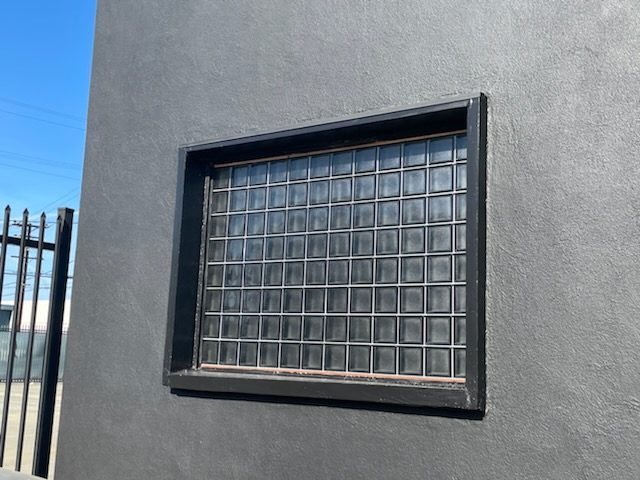glass block window with black trim on a dark gray building after painting. Preview Image 1
