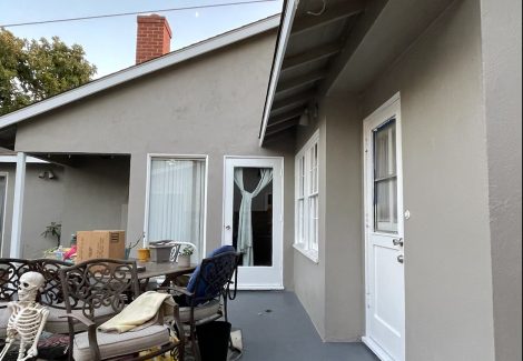 taupe colored stucco house with a gray concrete deck.