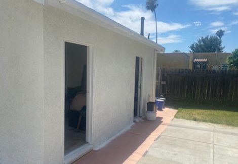 white stucco home with concrete patio after painting.