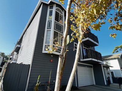 gray and white condo building with white garage doors.