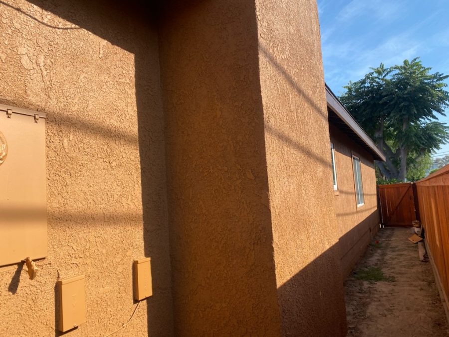 Side of house repainted in a dark tan over stucco. Preview Image 1