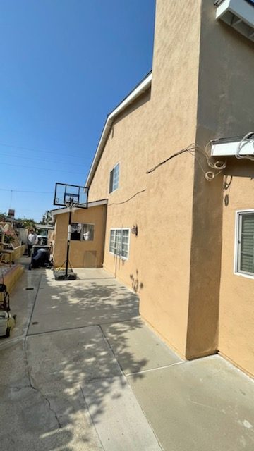 side of light tan stucco home with concrete decking. Preview Image 2