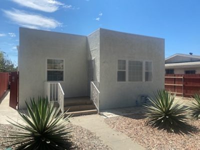 off white stucco home with a flat roof.