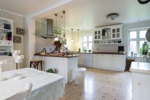 open kitchen with white cabinets and brown countertops with wood flooring