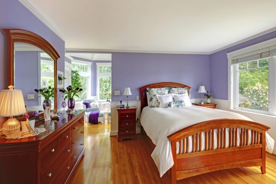 purple bedroom with wooden bed and furniture